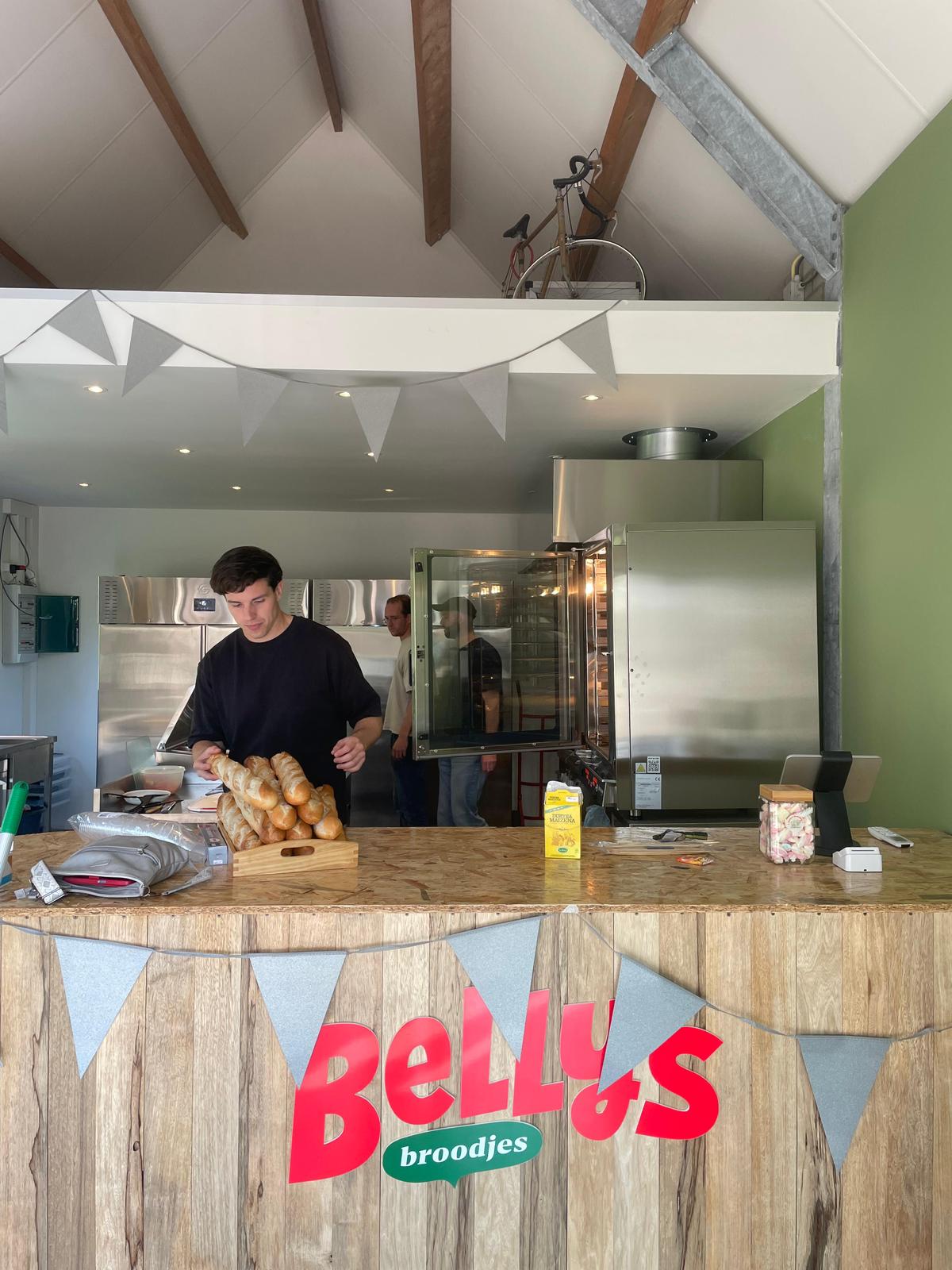 Nick achter de toonbank van Belly's Broodjes met verse stokbroden